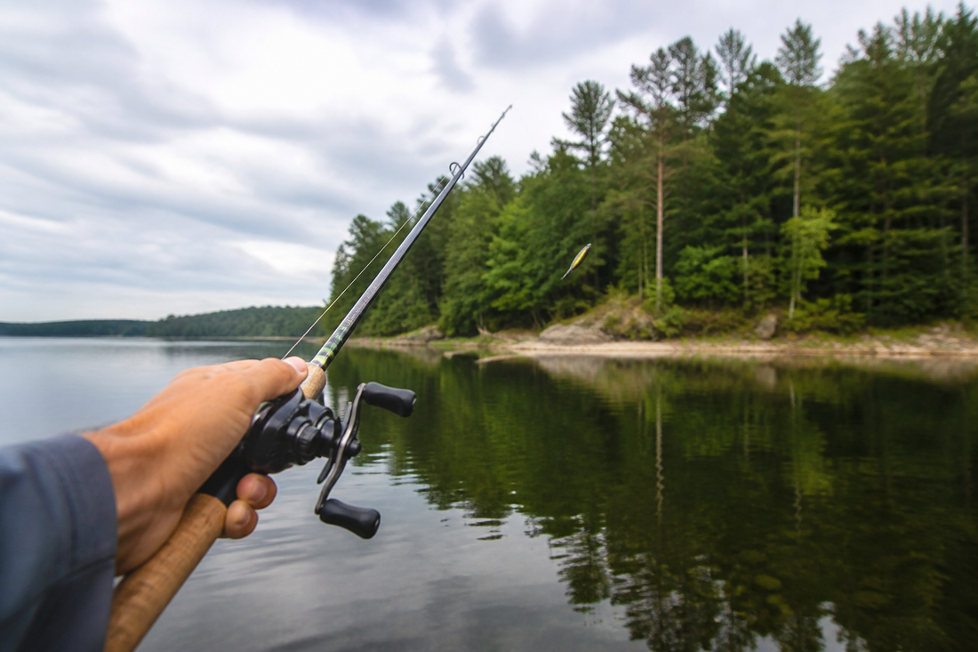 Angler making a smooth baitcasting cast toward a nearby shoreline target